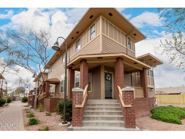 Inviting townhome with a brick-accented porch and a well-maintained front yard, promising comfort and style at 702 S Beck Ave, Tempe, AZ 85281