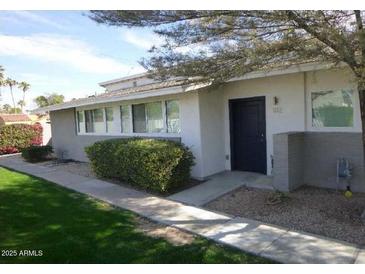 Charming single-level home features a well-manicured lawn, lush greenery, and a welcoming entrance at 925 W Mcdowell Rd # 102, Phoenix, AZ 85007