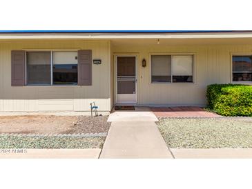 Inviting single-story home featuring a well-maintained front yard and a cozy entrance with decorative touches at 13642 N Silverbell Dr, Sun City, AZ 85351