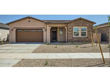 Charming single-story home with a two car garage and low maintenance desert landscaping in the front yard at 15053 W Gray Fox Trl, Surprise, AZ 85387