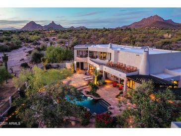 Gorgeous backyard showcasing a sparkling pool, lush landscaping, a patio with chairs, and mountain views at 22500 N 97Th St, Scottsdale, AZ 85255