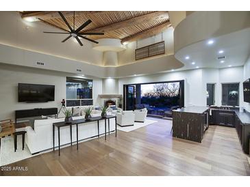 Beautiful living room featuring wood beam ceiling, fireplace and large windows, seamlessly opening to the pool area at 22500 N 97Th St, Scottsdale, AZ 85255