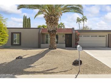 Charming single-story home with a desert landscape, palm tree, and a well-maintained front yard at 4001 E Cannon Dr, Phoenix, AZ 85028