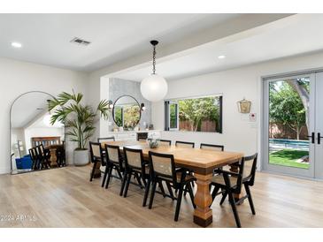 Bright dining room features a long wooden table, seating for ten and views of the backyard at 4216 N 42Nd St, Phoenix, AZ 85018