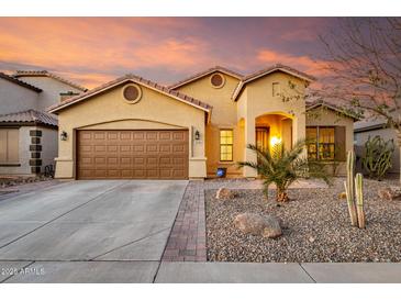 Charming single-Gathering home with a well-manicured front yard and two-car garage on a beautiful day at 43298 W Delia Blvd, Maricopa, AZ 85138