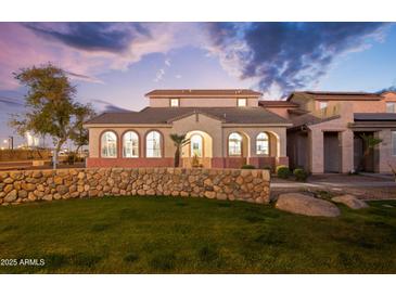 Charming two-story home with arched windows, stone wall, and well-manicured lawn at 5110 W Fulton St, Phoenix, AZ 85043