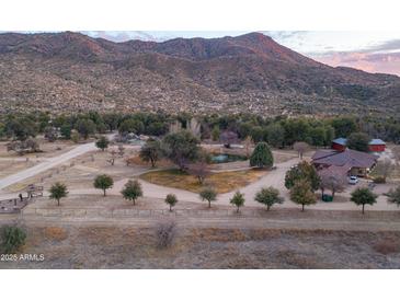 Expansive ranch property with winding paths and a charming pond against a backdrop of rugged mountains at 51238 N Pinal Ranch Rd, Miami, AZ 85539