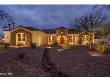 Charming single-story home featuring a stone facade, manicured desert landscaping, and a welcoming entrance at 9612 W Mariposa Grande --, Peoria, AZ 85383
