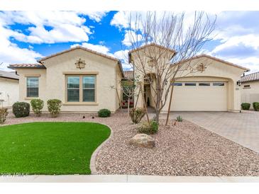 Charming single-story home with desert landscaping, artificial grass, and a two-car garage at 11721 W Parkway Ln, Avondale, AZ 85323