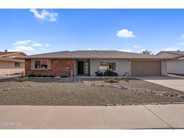 Charming single-story home featuring desert landscaping, brick accents and a two-car garage at 13235 W Ashwood Dr, Sun City West, AZ 85375