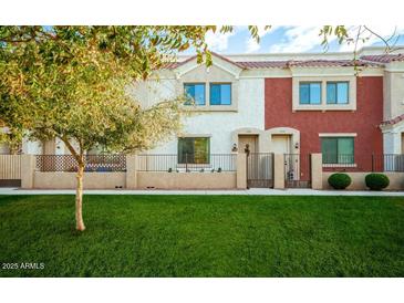 Attractive townhome with lush green lawn, small fence, and mature shade tree at 1950 N Center St # 111, Mesa, AZ 85201