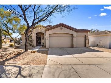 Charming single-story home with a three car garage, desert landscaping, and a well-manicured lawn at 22503 N 76Th Pl, Scottsdale, AZ 85255