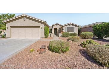 Charming single-story home with a well-manicured, low maintenance desert rock front yard landscape at 42808 W Whimsical Dr, Maricopa, AZ 85138