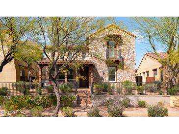 Charming two-story stone home with a cozy front porch and manicured landscaping at 9282 E Desert Vw, Scottsdale, AZ 85255