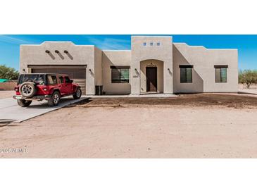 Charming single-Gathering home displaying neutral tones, a two-car garage, and desert landscaping at 12216 S 214Th Ave, Buckeye, AZ 85326