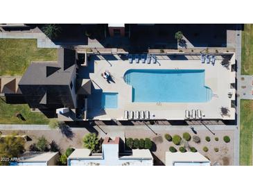 Aerial view of a community pool with lounge chairs, a large swimming pool, and a smaller wading pool at 1340 N Recker Rd # 219, Mesa, AZ 85205