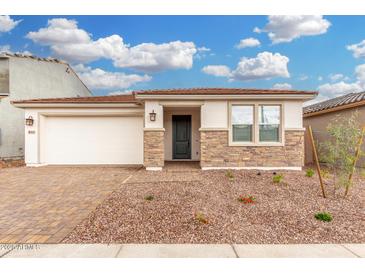 Charming single-story home featuring stone accents, a two-car garage, and low maintenance desert landscaping at 16804 W Yucatan Dr, Surprise, AZ 85388