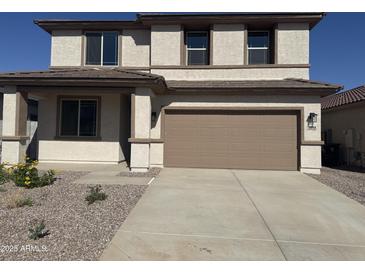 Two-story home with a two car garage and a well maintained front yard and desert landscaping at 16954 W Molly Ln, Surprise, AZ 85387