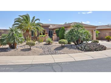 Attractive desert landscaping accents this tan home with a tile roof at 19437 N Guardian Ln, Surprise, AZ 85387