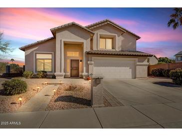 Charming two-story home with landscaped front yard and paved walkway with lovely nighttime lighting at 2130 E Knudsen Dr, Phoenix, AZ 85024