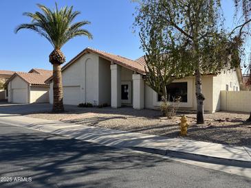 Charming single-story home features desert landscaping, a tile roof, and a front-facing two-car garage at 3703 N Wintergreen Way, Avondale, AZ 85392