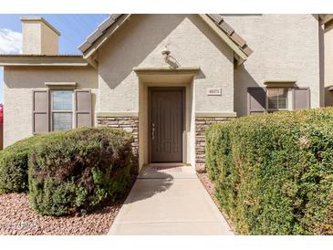 Charming home featuring a covered entry, a stone facade, and trimmed bushes along the walkway at 4675 E Olney Ave, Gilbert, AZ 85234