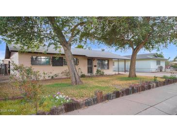 Charming single-story home with mature trees and inviting curb appeal at 6405 N 46Th Dr, Glendale, AZ 85301