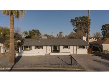 Charming single-story home featuring desert landscaping, a grey roof, and modern black accents on a bright sunny day at 7819 N 17Th Ave, Phoenix, AZ 85021