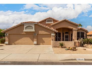 Charming single-story home featuring a two-car garage, desert landscaping, and a well-maintained facade under a partly cloudy sky at 7866 W Taro Ln, Glendale, AZ 85308