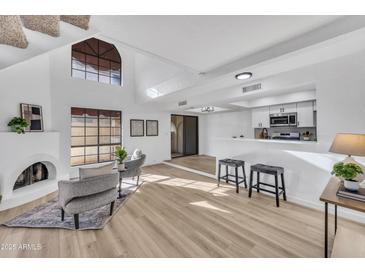 Bright living room features high ceilings, a fireplace, modern seating, and an open layout at 8840 S 51St St # 2, Phoenix, AZ 85044