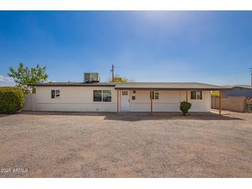 Charming single-story home with white exterior, desert landscaping, and covered entryway at 9127 E Broadway Rd, Mesa, AZ 85208