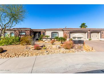 Charming home featuring a desert landscape with a two car garage and a red tile roof under a bright blue sky at 10534 N 133Rd St, Scottsdale, AZ 85259