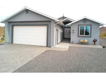Charming single-story home featuring a two-car garage, desert landscaping, and a welcoming entrance at 1127 N Sherwood Way, Queen Valley, AZ 85118