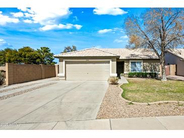 Charming single-story home with a two-car garage, desert landscaping, and a well-maintained lawn at 14398 W Marcus Dr, Surprise, AZ 85374