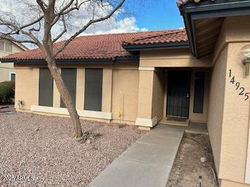 Charming single-story home with a tile roof and desert landscaping at 14925 N 91St Ln, Peoria, AZ 85381