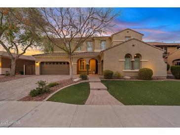 Charming two-story home featuring a landscaped front yard and a two-car garage with brick accents at 2670 E Parkview Dr, Gilbert, AZ 85295