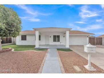 Charming single-story home featuring a covered porch, desert landscaping, and a well-maintained front yard at 11430 N 57Th Dr, Glendale, AZ 85304