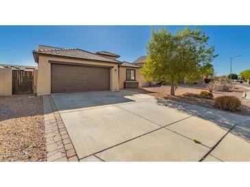 Charming single-story home with a two-car garage, concrete driveway and desert landscaping at 14787 W Aster Dr, Surprise, AZ 85379