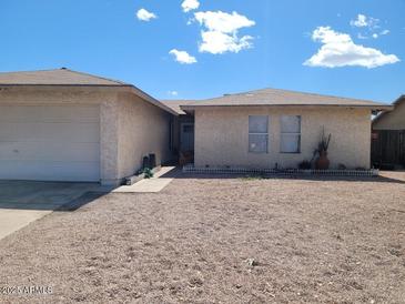 Charming single-story home featuring a low-maintenance gravel front yard under a clear blue sky at 155 W Hunter St, Mesa, AZ 85201