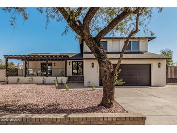 Charming two-story home featuring a covered porch, front yard landscaping, and a two-car garage at 15619 N 30Th Ave, Phoenix, AZ 85053