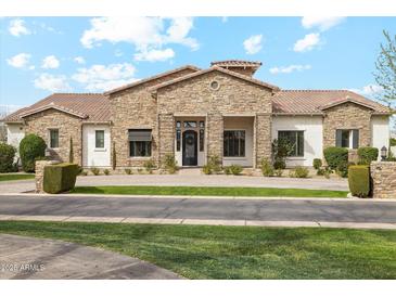 Stunning stone front exterior with manicured lawn, creating a welcoming and sophisticated curb appeal at 20216 E Sunset Ct, Queen Creek, AZ 85142