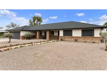 Charming single-story home featuring a gravel front yard, brick accents and a welcoming entrance at 2440 E Hale St, Mesa, AZ 85213