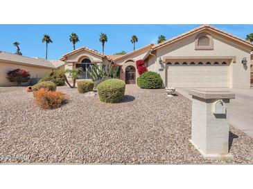 Charming home featuring desert landscaping, palm trees, and a two-car garage at 3032 N 160Th Ave, Goodyear, AZ 85395