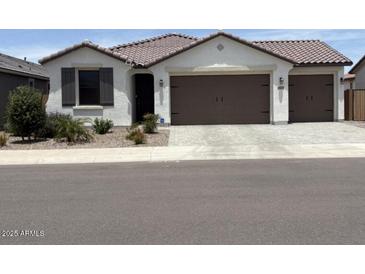 Charming single-story home with a two car garage, desert landscaping, and a neutral color palette at 40440 W Haley Dr, Maricopa, AZ 85138
