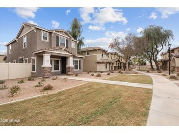 Charming two-story home with stone accents, covered entryway, and well-maintained lawn with community walkway at 5824 E Hoover Ave, Mesa, AZ 85206