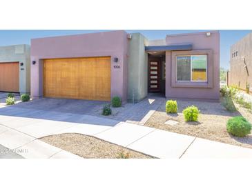 Contemporary home featuring a wooden garage door, modern front door, and desert landscaping at 9850 E Mcdowell Mountain Ranch Rd # 1006, Scottsdale, AZ 85260