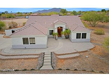 Charming single-story home featuring a tile roof, stucco exterior, and beautifully landscaped front yard at 130 E Jordon Ln, Phoenix, AZ 85086