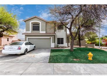 Two-story home with a two-car garage, neutral paint scheme, lawn, and mature trees at 1635 W Dunbar Dr, Phoenix, AZ 85041