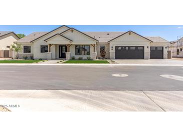 Charming single-story home with white exterior, stone accents, and a three-car garage at 1645 E Minton St, Mesa, AZ 85203