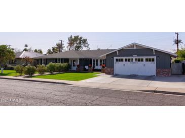 Charming home with manicured lawn, red brick accents and a two car garage at 4639 E Mulberry Dr, Phoenix, AZ 85018